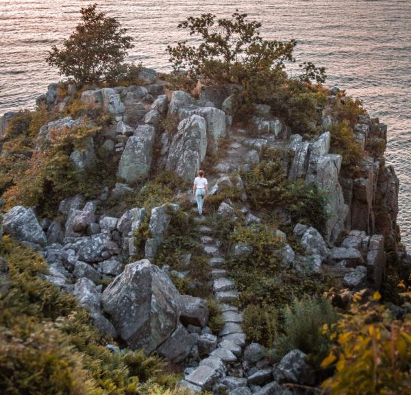 Een wandelaar beklimt de trap van Røverborgen op de Deense vakantiebestemming Bornholm
