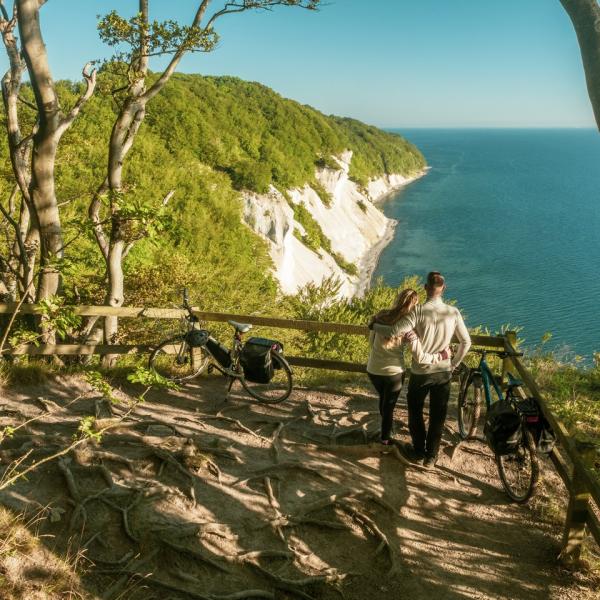 Een koppel geniet van het uitzicht op de witte krijtrotsen van Møns Klint in Denemarken