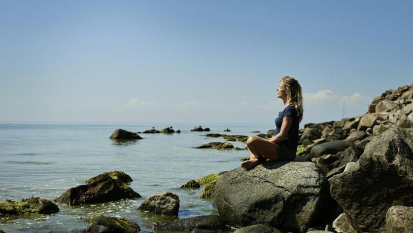 Lady sat relaxing on a beach in Bornholm