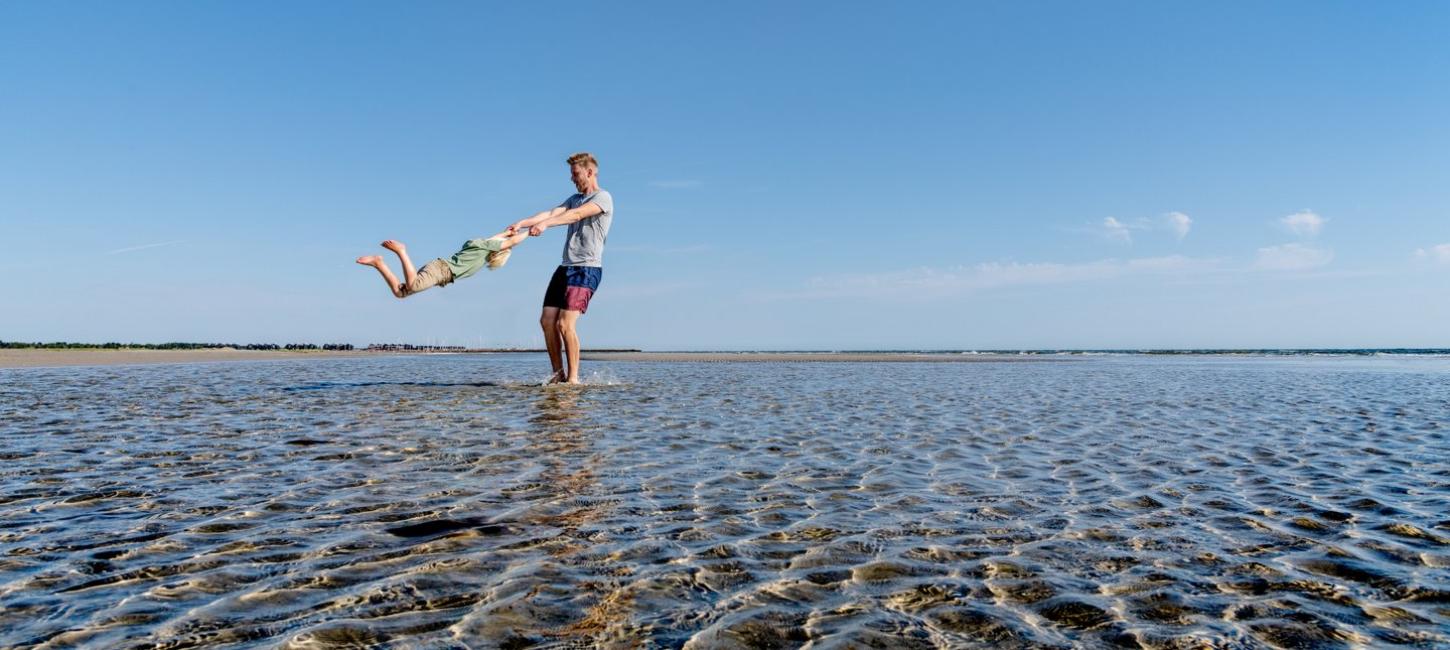 Vater spiel mit seinem Kind am Strand von Øster Hurup, Dänemark