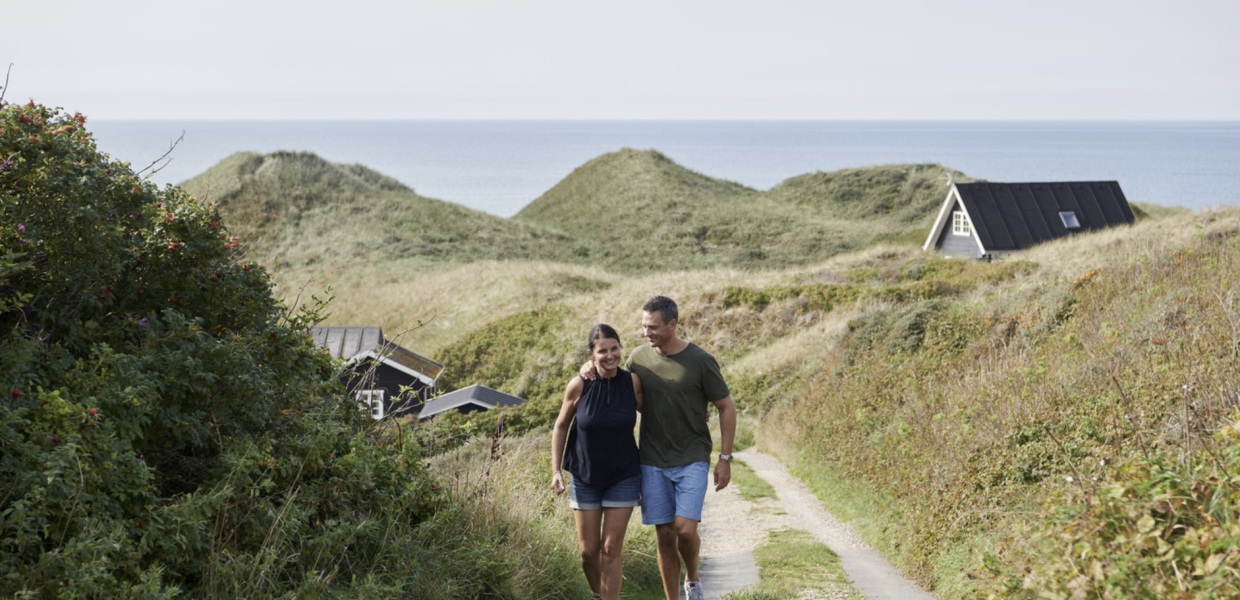 Een stel loopt langs een vakantiehuis in Hirtshals, Denemarken