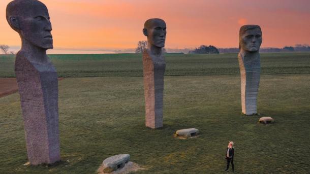 Person looking at stone sculptures Dodekalitten during sunset on Lolland-Falster, Denmark