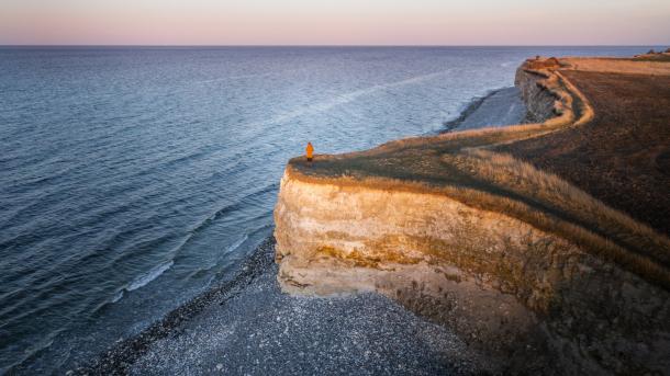Een wandelaar staat bovenop de Sangstrup Klint in Djursland in Oost-Jutland