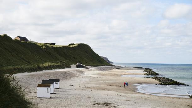 Wandelaars wandelen op het strand van Løkken in Noord-Jutland, Denemarken