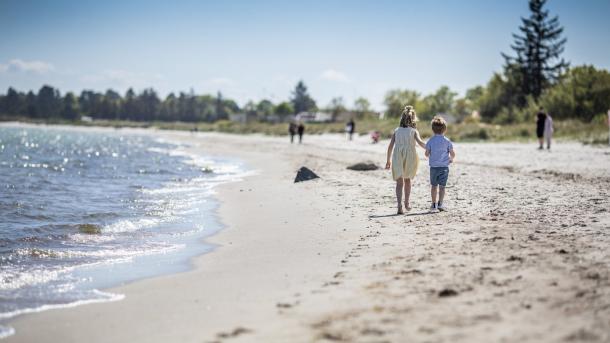Kinderen wandelen over het Saksild Strand in Denemarken