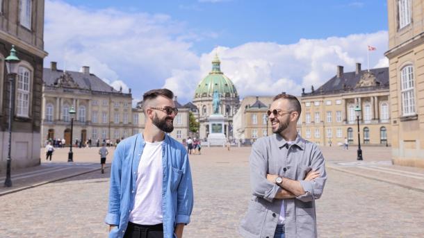 Reizigers verkennen Amalienborg in Kopenhagen, met op de achtergrond de mooie Marmorkirken
