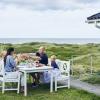 Famile ist Mittagessen auf der Terrasse eines Ferienhauses in Dänemark