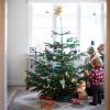 Familie dekoriert gemeinsam einen dänischen Weihnachtsbaum