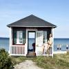 A lady sits at a beach house on Ærøskøbing Beach, Ærø, Denmark