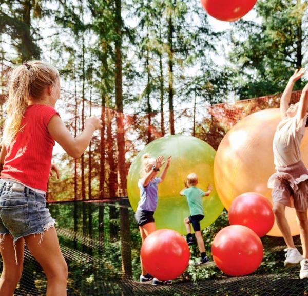 Kinder spielen mit Riesenbällen im WOW Park in Billund