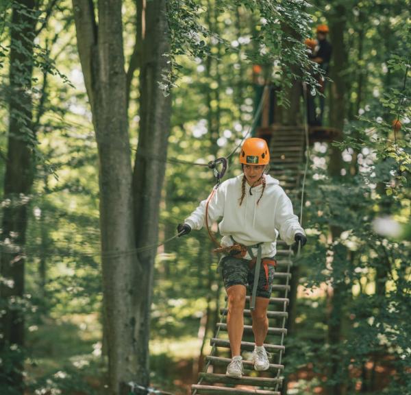 Een kind klimt met plezier in Camp Adventure in Denemarken