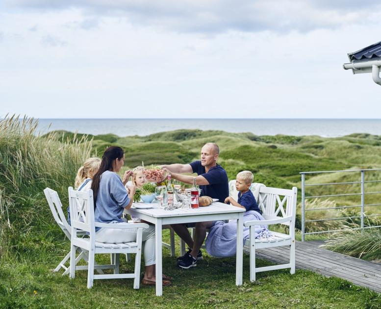 Familie spiser mat utenfor feriehus i Hirtshals