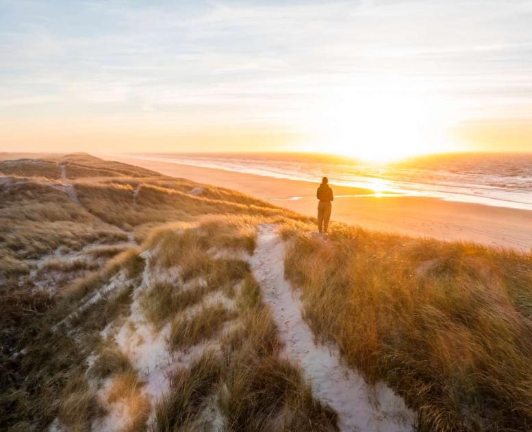 Een wandelaar kijkt naar de Deense Noordzee in de Vesterhavet regio
