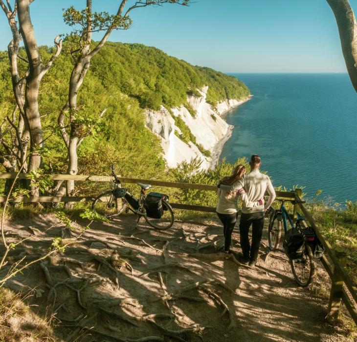 Een koppel geniet van het uitzicht op de witte krijtrotsen van Møns Klint in Denemarken